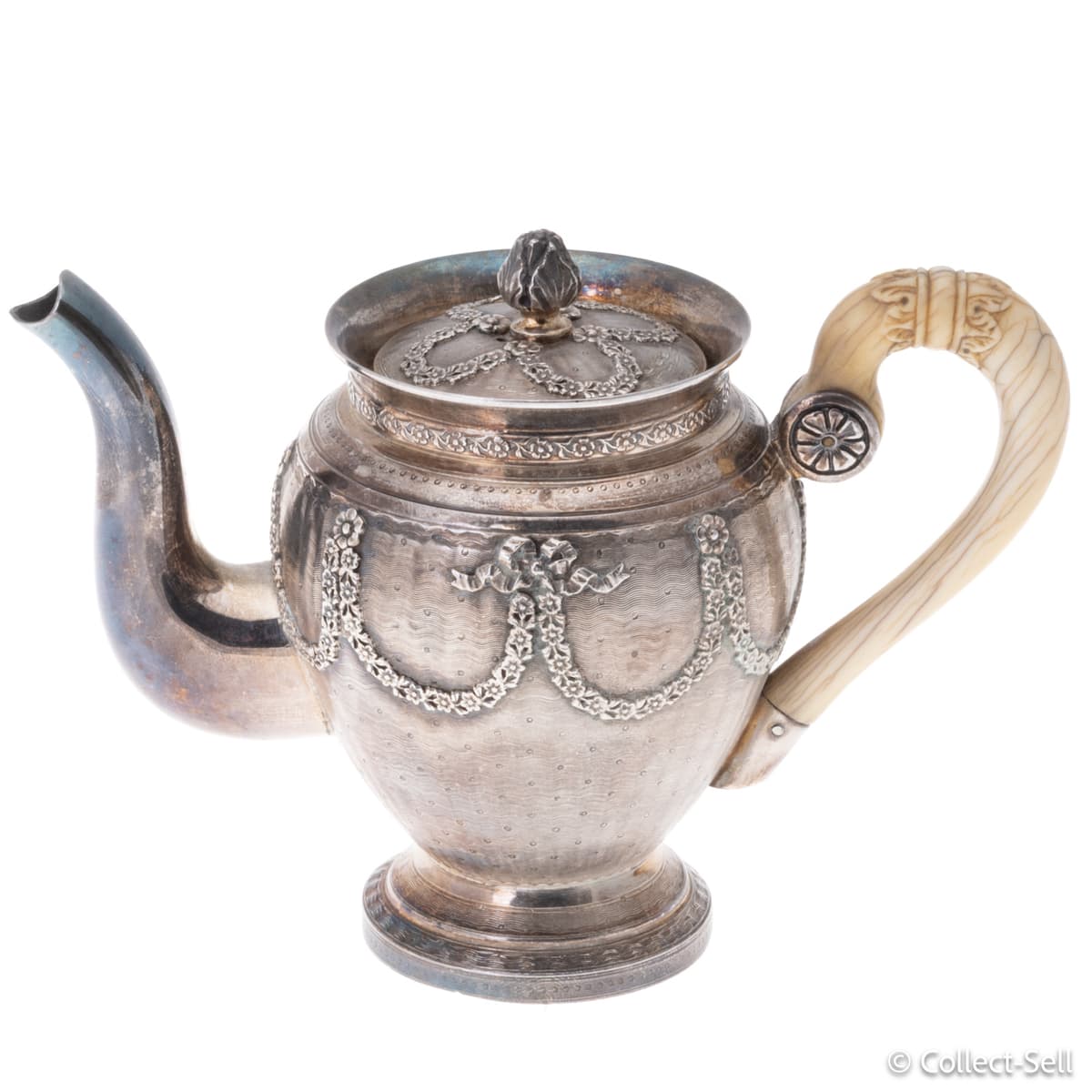 Right side of silver teapot with faux ivory handle and neoclassical garlands